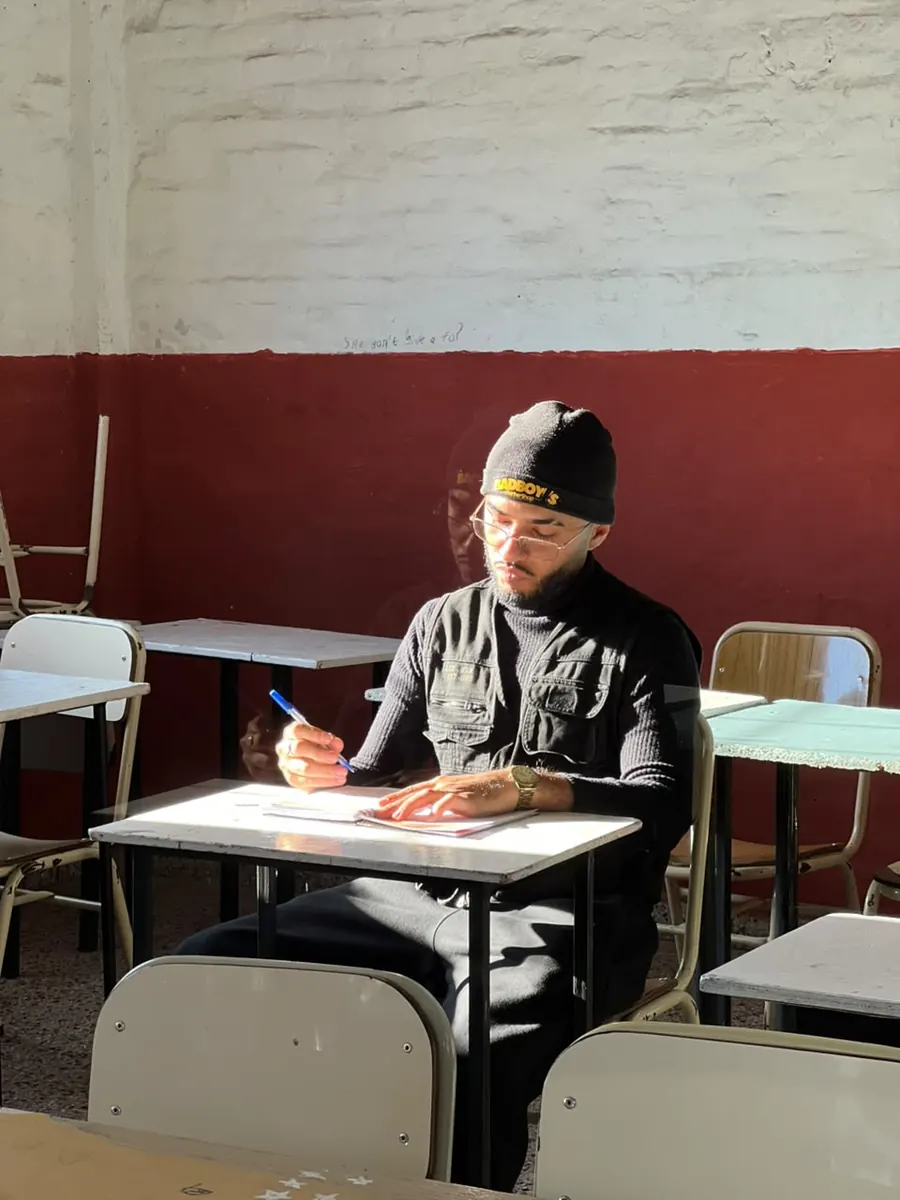 Ezequiel sentado en una mesa, anotando antes de un evento